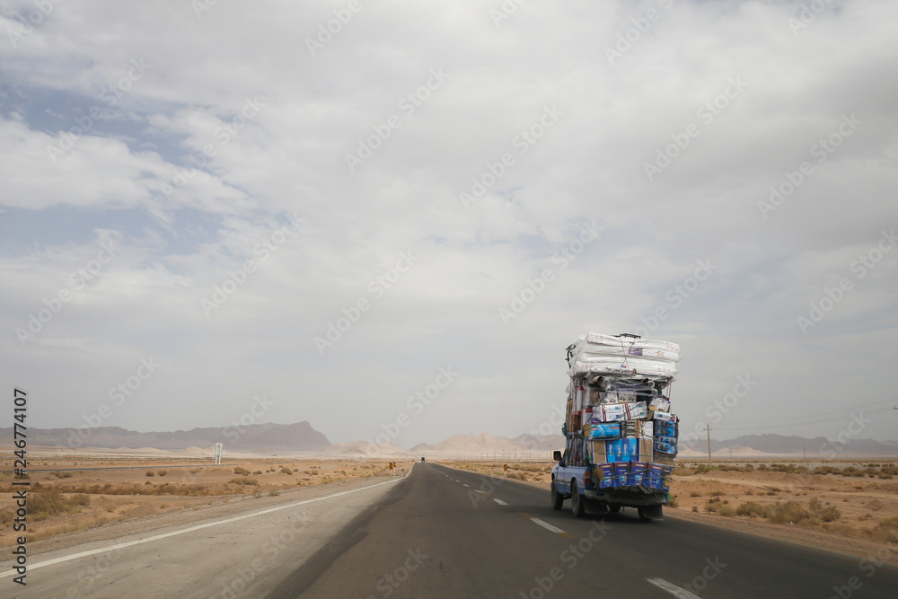Big truck carrying heavy load of water and other stuff is riding on a road from Isfahan to Yazd (Iran)