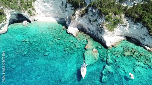  Aerial drone bird's eye view video of iconic tropical rocky paradise bay called blue lagoon with caves and turquoise clear waters visited by sail boats, island of Paxos, Ionian, Greece photo