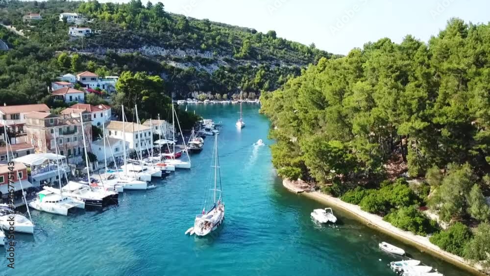 Aerial drone bird's eye view video of iconic small safe port of Gaios with traditional Ionian architecture and sail boats docked, Paxos island, Ionian, Greece