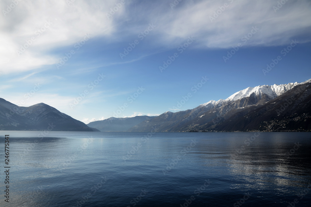 Alpine Lake Maggiore with Snow-capped Mountain and Blue Sky with Clouds in Switzerland.