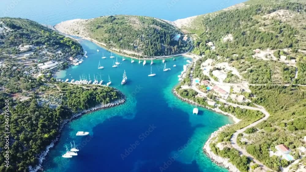Aerial drone bird's eye view video of tropical rocky small safe bay of Mogonisi with sail boats docked, Paxos island, Ionian, Greece Aerial drone bird's eye view video of tropical rocky small safe bay of Mogonisi with sail boats docked, Paxos island, Ionian, Greece