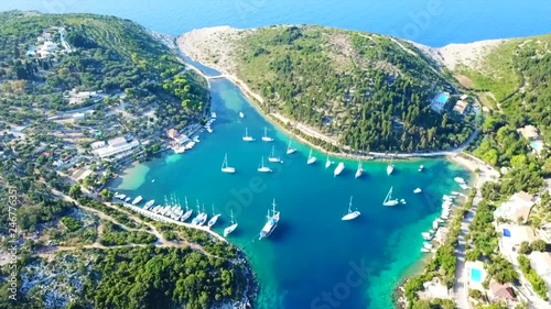Aerial drone bird's eye view video of tropical rocky small safe bay of Mogonisi with sail boats docked, Paxos island, Ionian, Greece photo