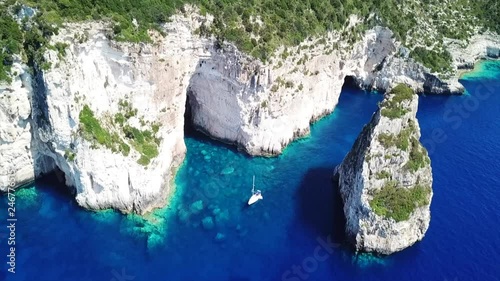 Aerial drone bird's eye view video of tropical rocky bay of Ortholithos with famous cave of Papanikolis and turquoise calm waters forming a blue lagoon photo