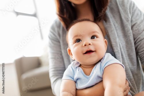 childhood and family concept - close up of asian baby boy with mother