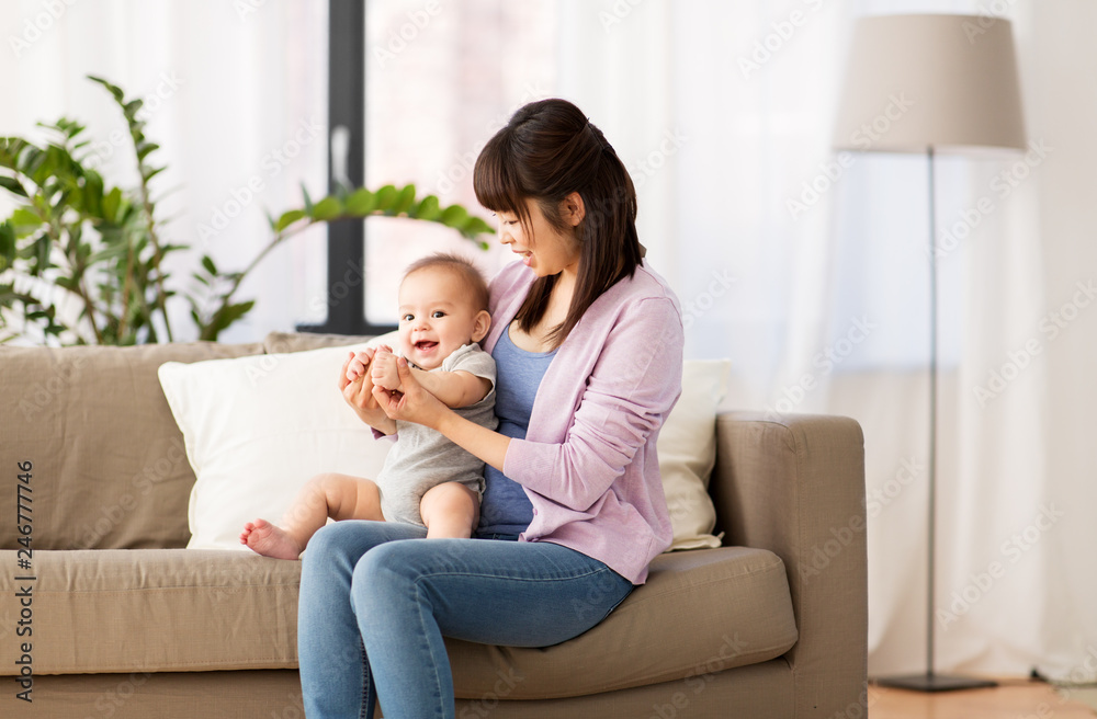 family and motherhood concept - happy smiling young asian mother with little baby son at home
