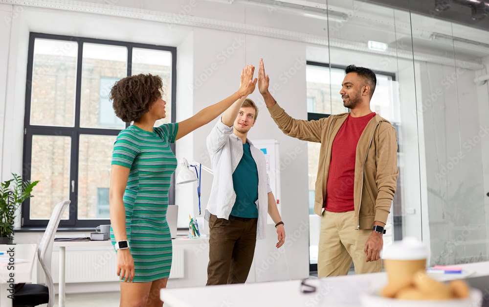 Obraz premium business, teamwork and corporate concept - happy creative team making high five at office