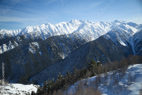Snowy Causasus mountain peaks with white clouds and blue sky in Mestia, Svaneti (Svanetia) region of Georgia