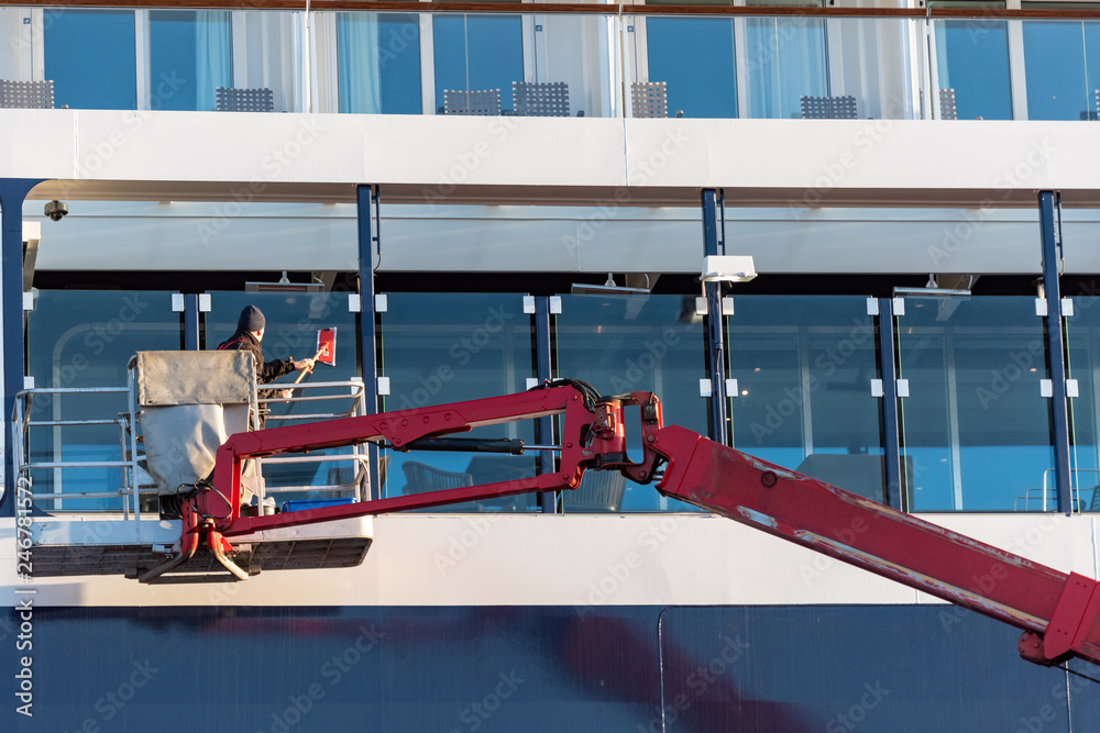 Naklejka premium Fensterputzer reinigt die Außenscheiben an einem Kreuzfahrtschiff