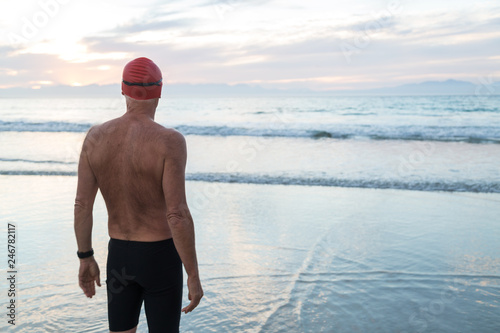 Senior man preparing to swim in the sea at dawn