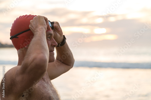 Senior man preparing to swim in the sea at dawn