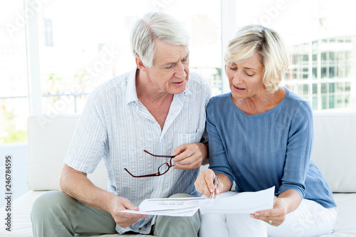 Senior couple doing home finance - fake bill - women smiling
