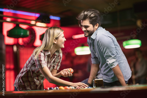 billiard – smiling couple sorting balls for beginning game. photo