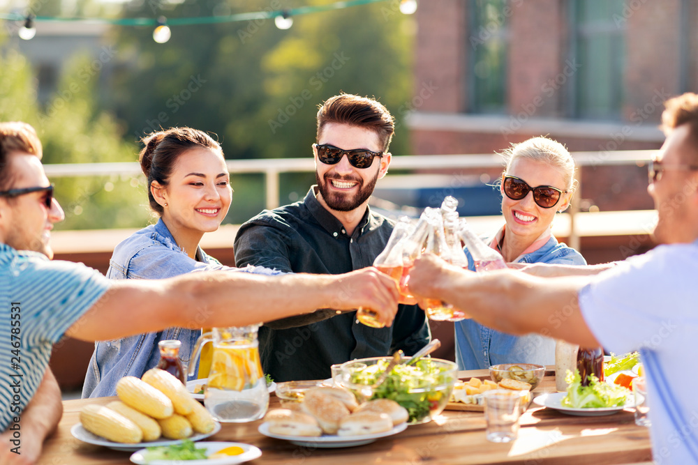 leisure and people concept - happy friends toasting non alcoholic drinks at rooftop party in summer