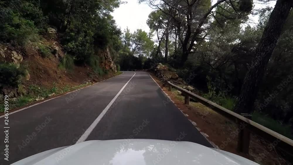 mountain drive. POV from the drivers perspective through a winding mountain road on a rock and tree lined highway on a sunny day with blue skies. mountain drive. POV from the drivers perspective through a winding mountain road on a rock and tree lined highway on a sunny day with blue skies.
