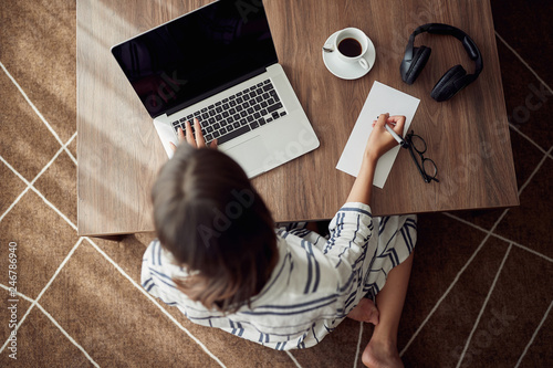 Foto Working home concept -Woman using a laptop computer for work at home top view