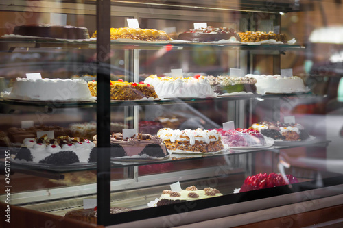 Tablou pe pânză Appetizing cakes in the window of a pastry shop