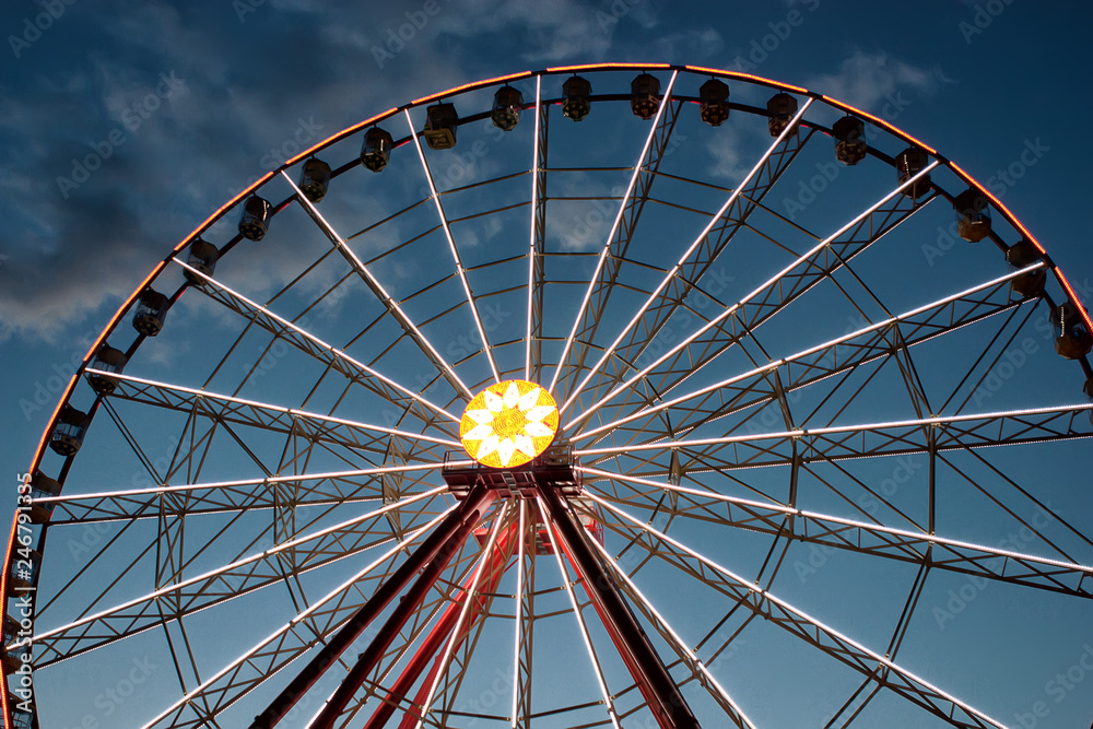 Fototapeta premium attraction Ferris wheel against a background of evening dark blue sky with clouds