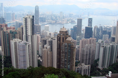 A view from above to a variety of skyscrapers of a modern Southern Asian megapolis surrounding the sea bay along its coast.