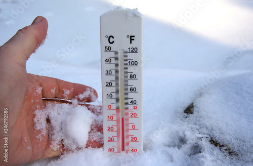 Thermometer on snow shows freezing temperature in celsius or farenheit