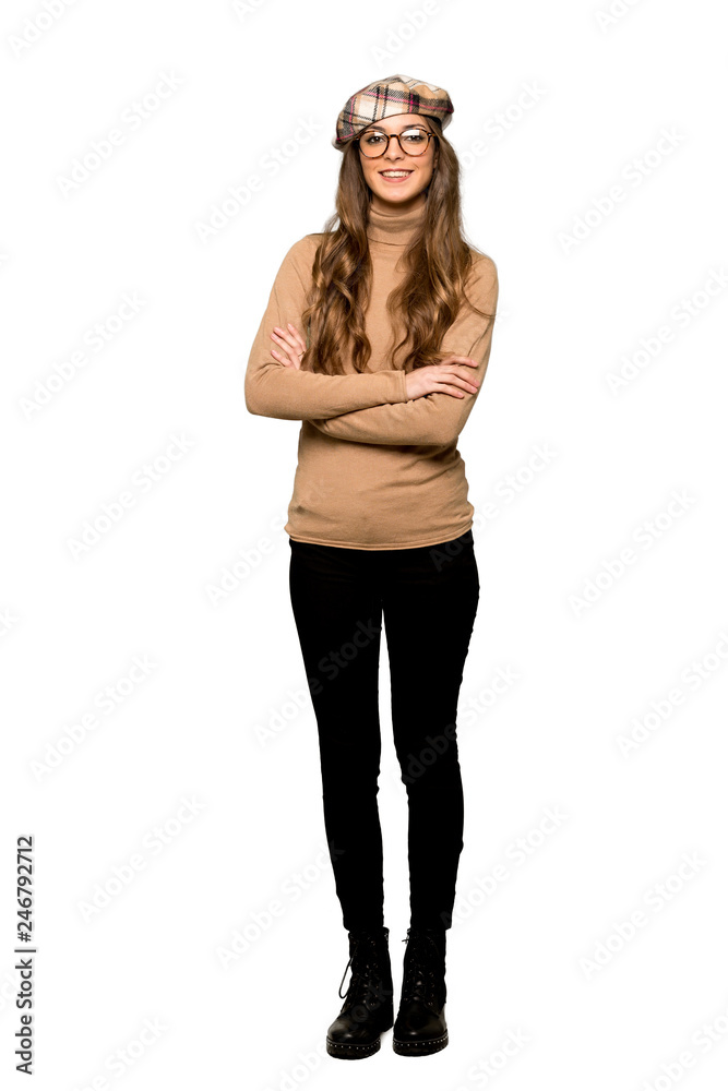 Fototapeta premium Full-length shot of Young woman with beret keeping the arms crossed in frontal position on isolated white background