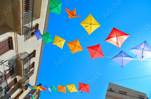 Sciacca, Sicily:  Colored umbrellas on the street in historical part of old city of Sciacca against blue sky .