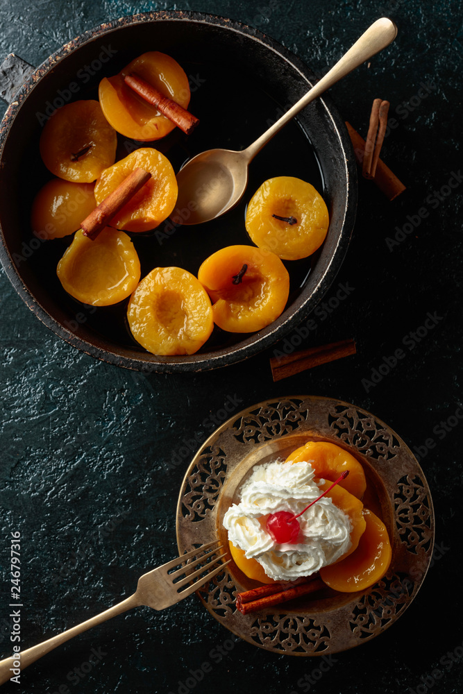 Peach dessert with cinnamon, cream and cherry.
