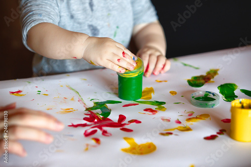 child paints and fingers