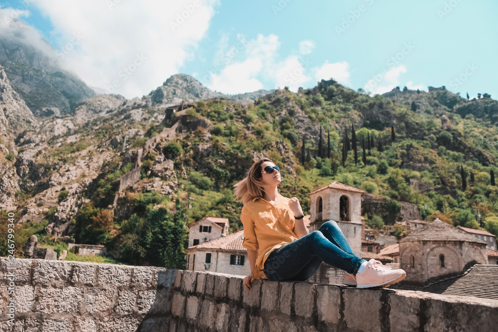 Girl on the background of the high mountains of Montenegro. Style of life, travel. Old City of Kotor