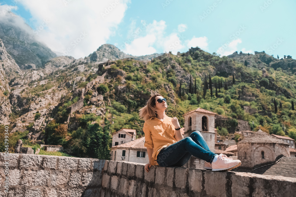 Girl on the background of the high mountains of Montenegro. Style of life, travel. Old City of Kotor Girl on the background of the high mountains of Montenegro. Style of life, travel. Old City of Kotor
