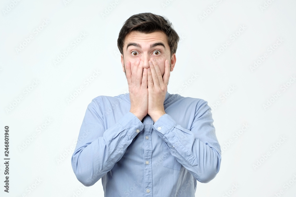 Young hispanic man covering his mouth with hand Young hispanic man covering his mouth with hand