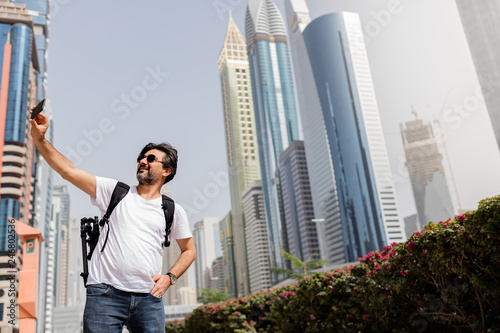 Photography Adult tourist taking selfie in downtown city.