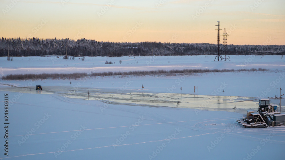 Car is crossing frozen river in northern Europe