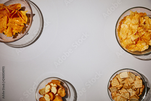 top view of delecious snacks in bowls on white background photo