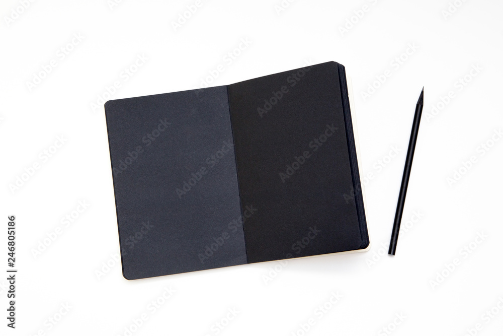 Notebook with black paper and pencil on white background. Workplace of the artist or writer. Kraft paper, top view. close-up, mockup. Notebook with black paper and pencil on white background. Workplace of the artist or writer. Kraft paper, top view. close-up, mockup.