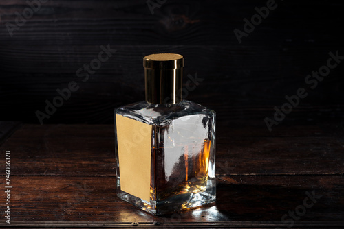 close-up view of bottle of whisky with blank label on brown wooden table