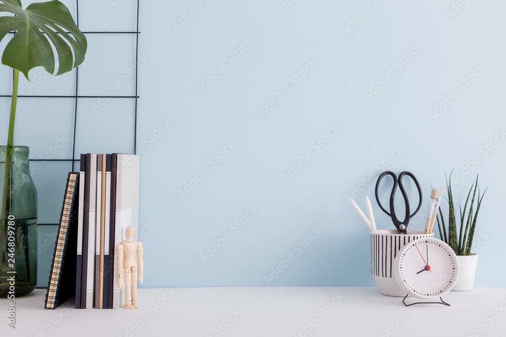 Office desk with supplies, and blue wall mock up. - obrazy, fototapety, plakaty 