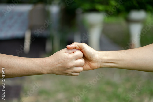 hand holds together in the community in the garden / park. © Surachetsh