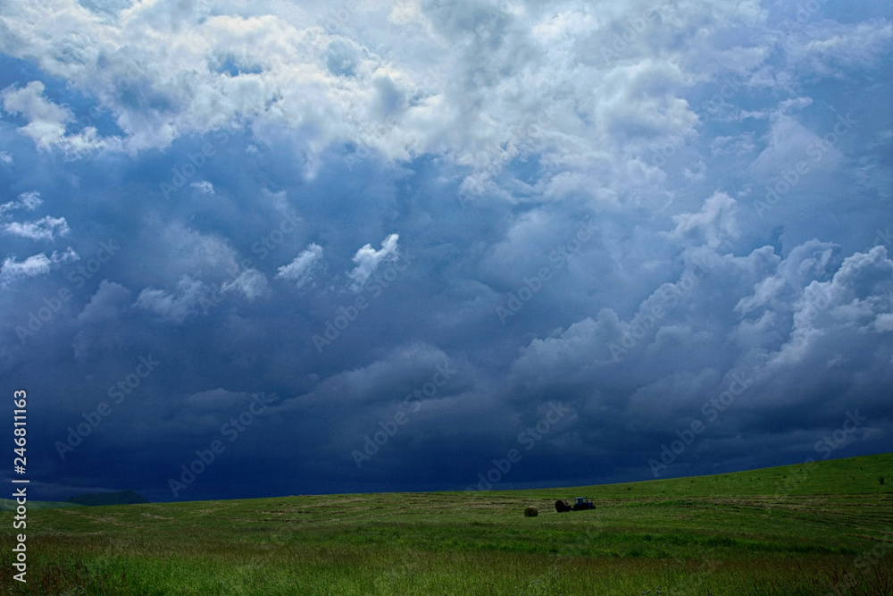 Beautiful clouds in the sky over a green meadow on a sunny summer day Beautiful clouds in the sky over a green meadow on a sunny summer day
