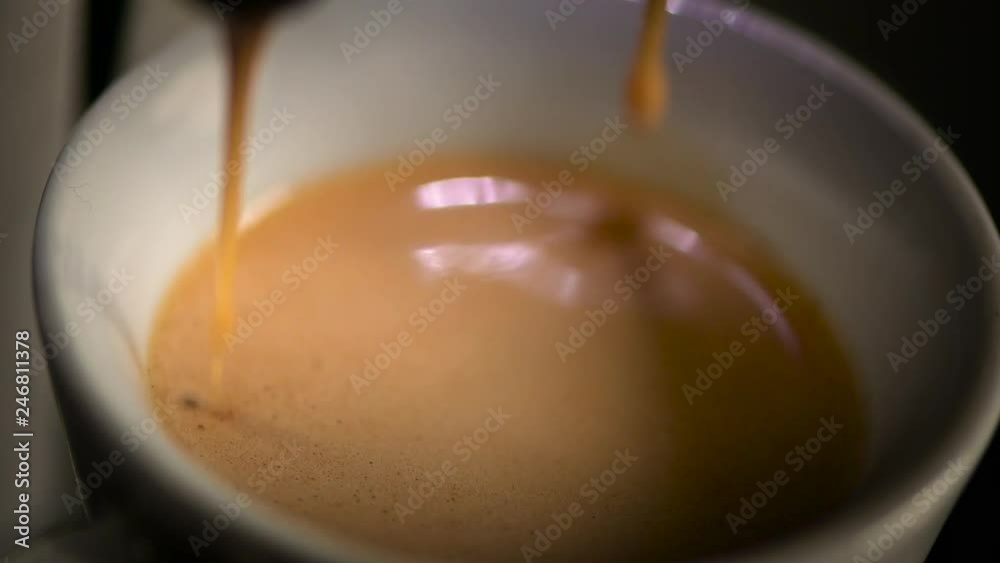 close-up of espresso running, dripping, pouring in a white cup, slow-motion and a lot of blur close-up of espresso running, dripping, pouring in a white cup, slow-motion and a lot of blur