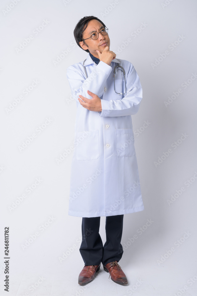 Full body shot of Japanese man doctor thinking