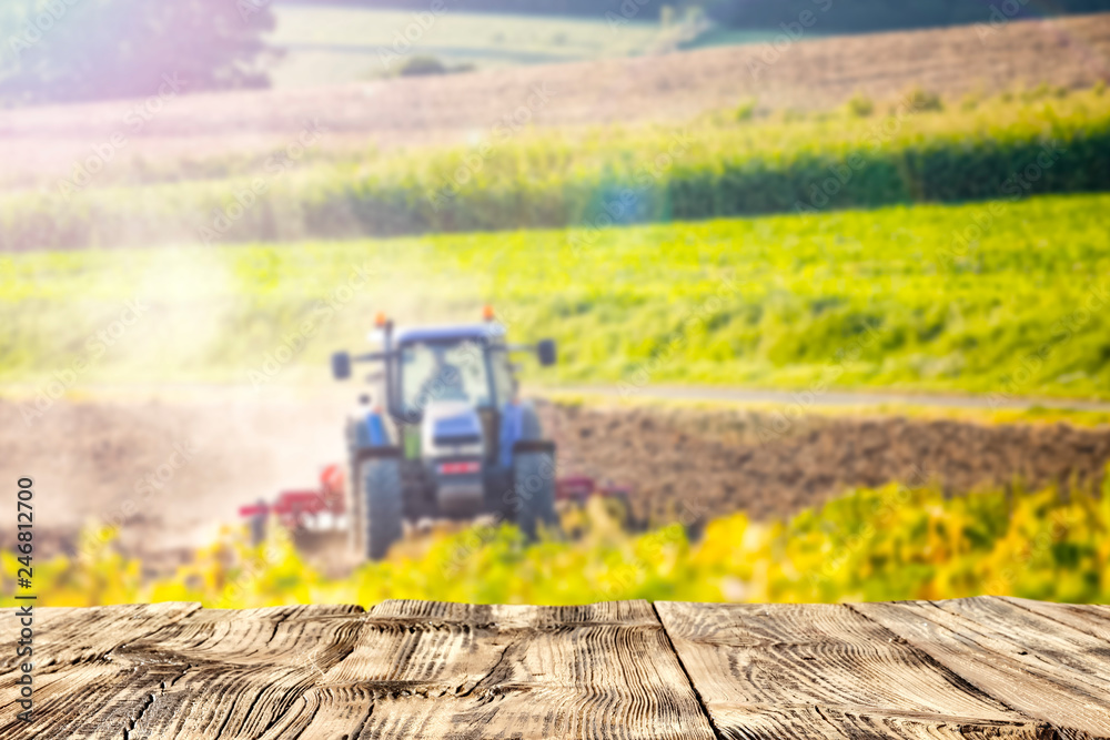 Table background of free space and spring rural landscape with tractor Table background of free space and spring rural landscape with tractor