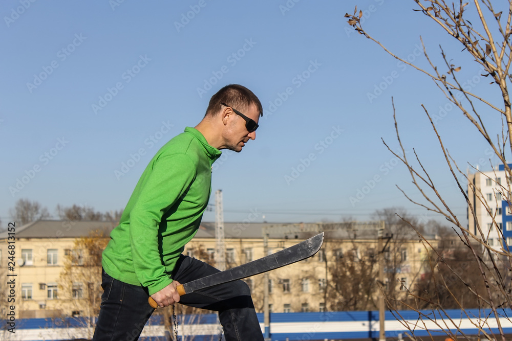 Angry man with swords in green hoodie Angry man with swords in green hoodie