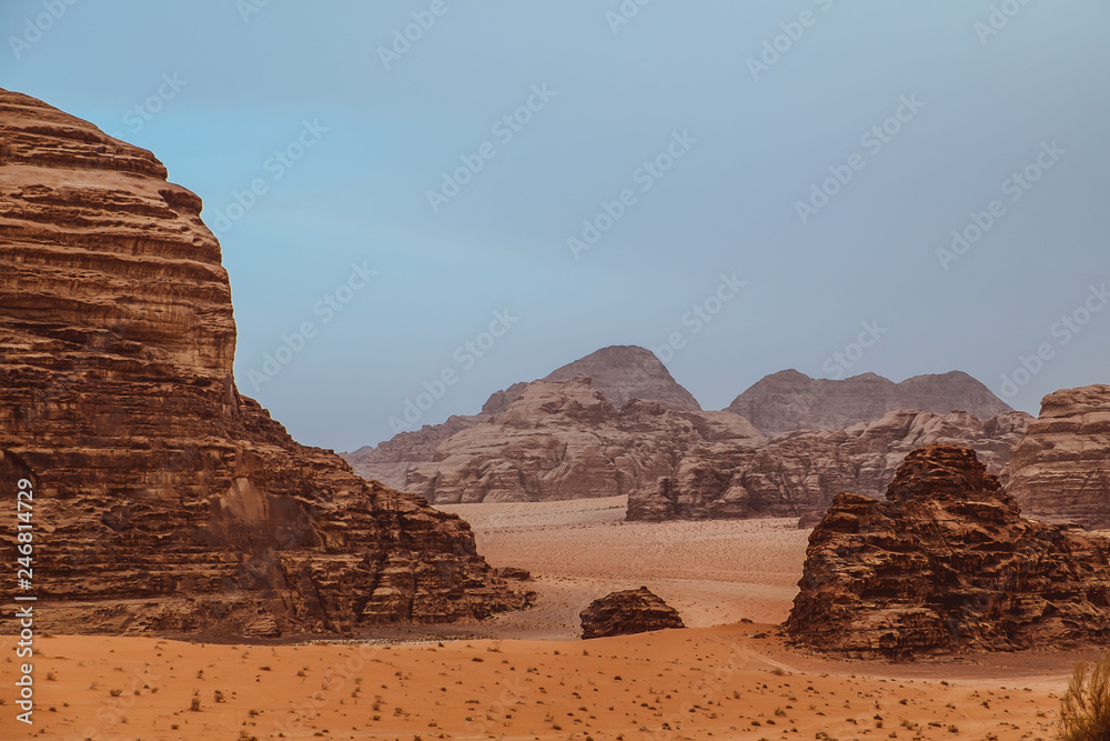 Red mountains of the canyon of Wadi Rum desert in Jordan. Wadi Rum also known as The Valley of the Moon is a valley cut into the sandstone and granite rock in southern Jordan to the east of Aqaba. Red mountains of the canyon of Wadi Rum desert in Jordan. Wadi Rum also known as The Valley of the Moon is a valley cut into the sandstone and granite rock in southern Jordan to the east of Aqaba.