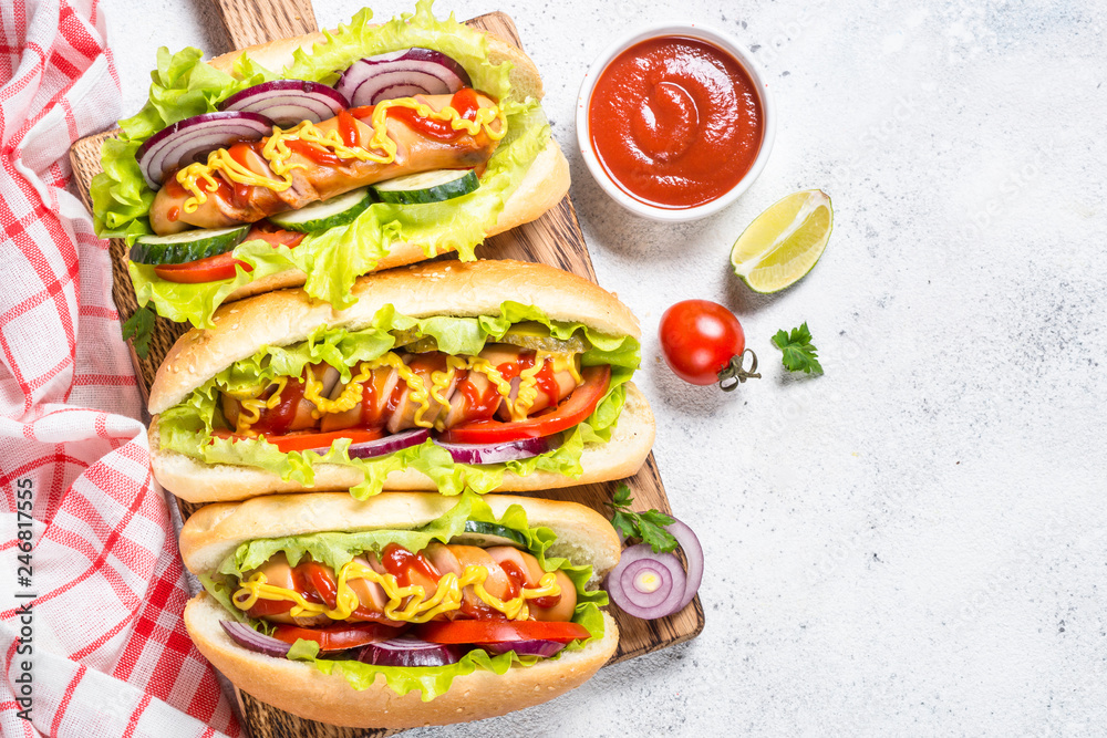 Hot dog with fresh vegetables on white top view. Hot dog with fresh vegetables on white top view.
