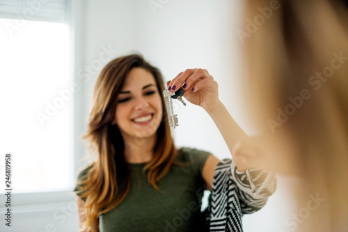 Smiling Caucasian women holding keys of new apartment
