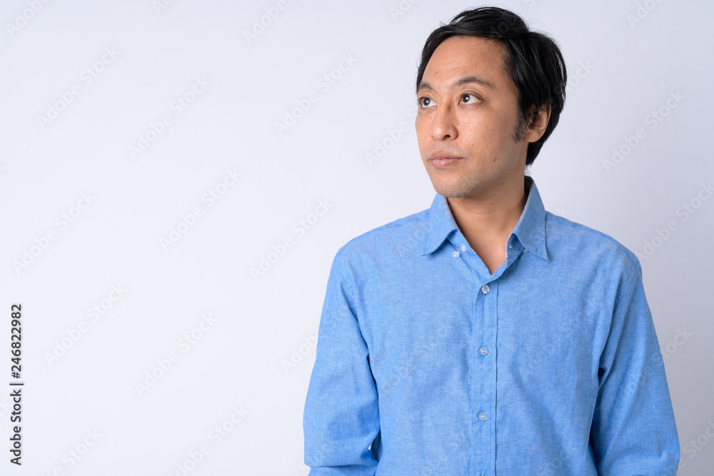 Portrait of Japanese businessman thinking against white background Portrait of Japanese businessman thinking against white background