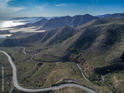 Aerial view on spanish mountains and a road to the sea with loops. Cartagena, Costa Blanca, Spain.
