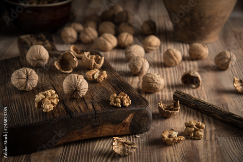Close up view composition of walnut kernels and whole walnuts on rustic cuting desk. Selective focus 2