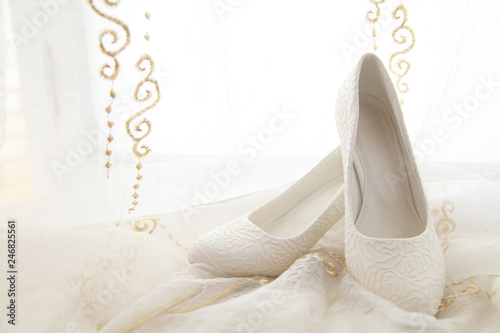 White female wedding shoes on translucent fabric