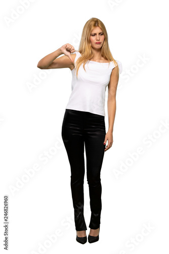 Young blonde woman showing thumb down with both hands over isolated white background © luismolinero